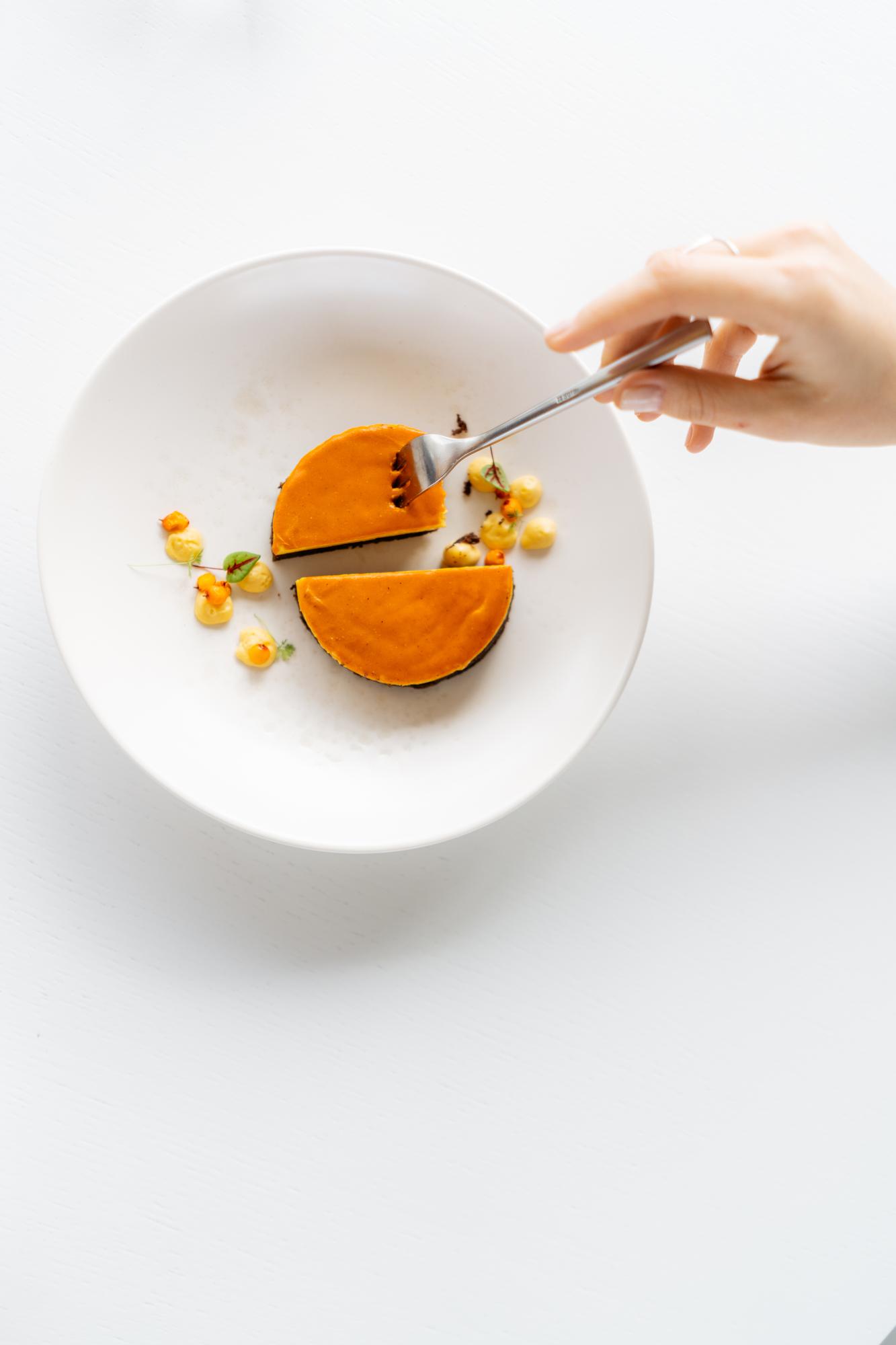 Chef plating a simple composed dish on neutral plate